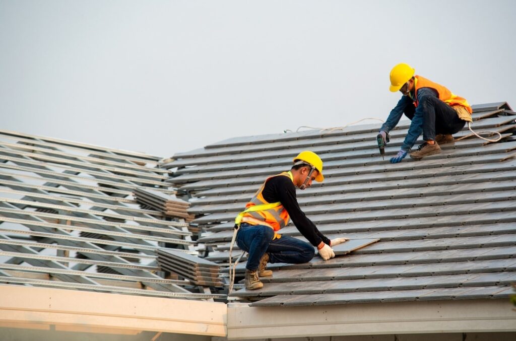 stock-photo-roofer-worker-in-special-protective-work-wear-and-gloves-using-pneumatic-gun-and-installing-1677474502-transformed-min